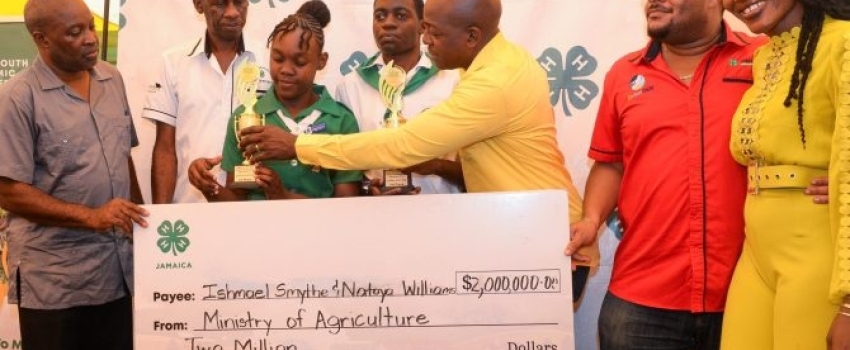 Minister of Agriculture and Fisheries, Hon. Pearnel Charles Jr. (third left), hands the first-place trophy to the 4-H Girl of the Year, Natoya Williams (third right), while Boy of the Year, Ishmael Smythe (fourth right), looks on. The two, who were crowned during the National 4-H Achievement Day Expo at the Denbigh Showground on May 12, also received a monetary prize. Sharing in the moment are (from left) Permanent Secretary in the Ministry of Agriculture and Fisheries, Dermon Spence; Acting Executive Direc