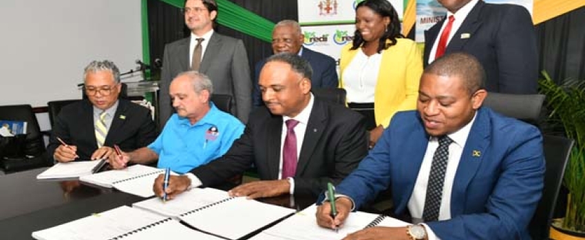 Minister of Agriculture, Fisheries and Mining, Hon. Floyd Green (seated right); Managing Director, Jamaica Social Investment Fund (JSIF), Omar Sweeney (seated second right); Director of Projects, Champion Industrial Equipment and Supplies Limited, Courtney Harford (seated second left) and Chief Executive Officer, Agro-Investment Corporation, Vivion Scully, affix their signatures to documents for the implementation of the Agro-Investment Corporation irrigation Transmission Force Main and Equipping project, a