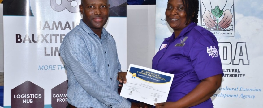 Chief Technical Director in the Ministry of Agriculture, Fisheries & Mining, Courtney Cole, presents a certificate to Nordia Greaves at the Rural Agricultural Development Authority (RADA) Farmer Field School Graduation Ceremony held at Moneague College, St. Ann on Thursday (September 7).