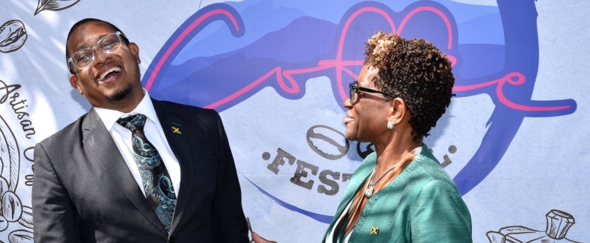 Minister of Agriculture, Fisheries and Mining, Hon. Floyd Green (left), enjoys a good laugh with Executive Director of Devon House, Georgia Robinson, during Tuesday's (January 9) launch of Blue Mountain Coffee Festival, held at Devon House in Kingston.