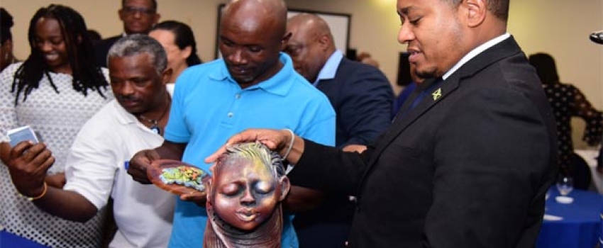 Minister of Agriculture, Fisheries and Mining, Hon. Floyd Green (right) admires a sculpture done by Artist and Founder, Khadabra Limited, Robert Campbell (left) during the Organization of African, Caribbean and Pacific States (OACPS)/ European Union (EU)/United Nations Development Programme (UNDP) development minerals programme final conference on Wednesday (October 18) at the Jamaica Pegasus Hotel in New Kingston. 