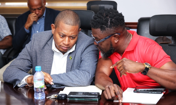 Minister of Agriculture, Fisheries and Mining, Hon. Floyd Green (left), converses with GraceKennedy (GK) General Insurance Company Limited’s Client and Partner Services Manager, Orette Duncan, during the handover ceremony for an insurance payout totalling $2.88 million to registered farmers affected by Hurricane Melissa. The payout was disbursed under the GraceKennedy Weather Protection Programme administered by GraceKennedy (GK) General Insurance Company Limited. The ceremony was held at the Ministry of Ag