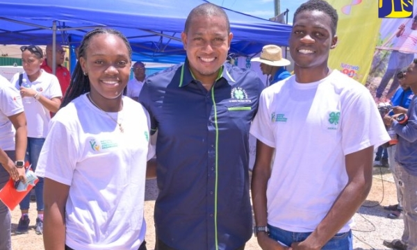 Minister of Agriculture, Fisheries and Mining, Hon. Floyd Green, shares a photo opportunity with Jamaica 4-H Clubs Champion Boy, Ishmael Smythe (right) and Champion Girl, Natoya Williams, during the recent Denbigh Agricultural, Industrial, and Food Show at the Denbigh Showground in Clarendon.  