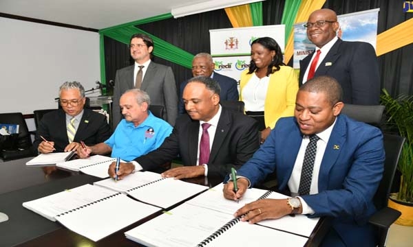 Minister of Agriculture, Fisheries and Mining, Hon. Floyd Green (seated right); Managing Director, Jamaica Social Investment Fund (JSIF), Omar Sweeney (seated second right); Director of Projects, Champion Industrial Equipment and Supplies Limited, Courtney Harford (seated second left) and Chief Executive Officer, Agro-Investment Corporation, Vivion Scully, affix their signatures to documents for the implementation of the Agro-Investment Corporation irrigation Transmission Force Main and Equipping project, a