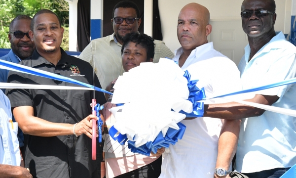 Minister of Agriculture, Fisheries and Mining, Hon. Floyd Green (left; foreground) leads a ribbon cutting exercise symbolising the official handover of  a communal milking parlour in Hillside, St. Thomas, on November 7. Joining the Minister are (from left) Chief Executive Officer of the Jamaica Dairy Development Board (JDDB), Devon Sayers; Chairman of the JDDB, Dr. Derrick Deslandes; Councillor Caretaker for the Seaforth Division, Sheroo Stevens; Member of Parliament for St. Thomas Western, James Robertson;