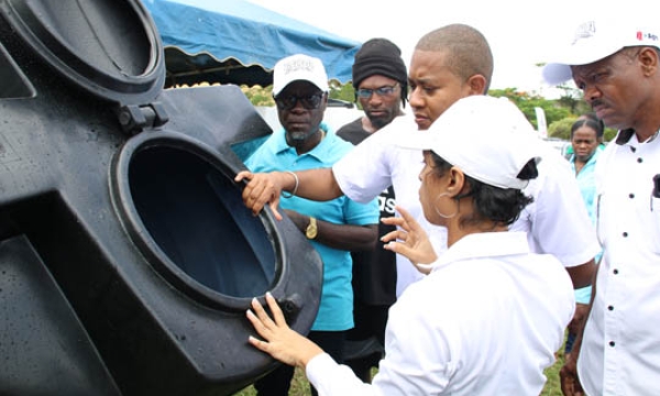 Business Development Manager at Rock Solid Plastics Limited, Ashley Neisbeth (centre), and Minister of Agriculture, Fisheries and Mining, Hon Floyd Green (third from left), look inside an empty water tank created by Rock Solid Plastics Limited at the St. Bess Agri-Fest held at the Santa Cruz Community Centre SDC Complex on Friday, June 9, 2023. Looking on are Acting Chief Executive Officer for the Rural Agricultural Development Authority (RADA), Winston Simpson (left), and Senior Director of Production, Mar