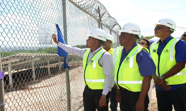 Minister of Agriculture, Fisheries and Mining, Hon Floyd Green (left), unveils a plaque containing information about the Plumwood Pumping Station Photovoltaic (PV) System at the Official Handing-Over Ceremony at the Plumwood Pumping Station in New Forest, Manchester on Thursday, June 15, 2023. Looking on from left are Minister of State at the Ministry of Agriculture, Fisheries and Mining, Hon Franklin Witter, and Managing Director at the Jamaica Social Investment Fund, Omar Sweeney.