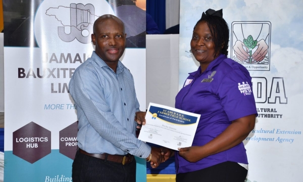 Chief Technical Director in the Ministry of Agriculture, Fisheries & Mining, Courtney Cole, presents a certificate to Nordia Greaves at the Rural Agricultural Development Authority (RADA) Farmer Field School Graduation Ceremony held at Moneague College, St. Ann on Thursday (September 7).