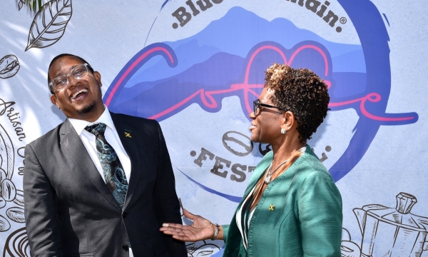 Minister of Agriculture, Fisheries and Mining, Hon. Floyd Green (left), enjoys a good laugh with Executive Director of Devon House, Georgia Robinson, during Tuesday's (January 9) launch of Blue Mountain Coffee Festival, held at Devon House in Kingston.