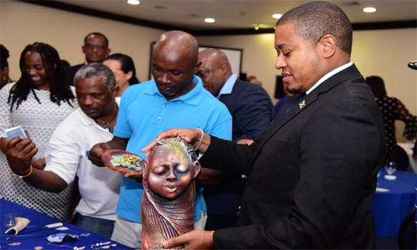 Minister of Agriculture, Fisheries and Mining, Hon. Floyd Green (right) admires a sculpture done by Artist and Founder, Khadabra Limited, Robert Campbell (left) during the Organization of African, Caribbean and Pacific States (OACPS)/ European Union (EU)/United Nations Development Programme (UNDP) development minerals programme final conference on Wednesday (October 18) at the Jamaica Pegasus Hotel in New Kingston. 